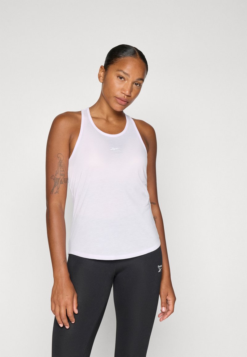 Hvid tanktop med rund hals, lavet af letvægtsmateriale. Har et lille logo i midten og er parret med sorte leggings.