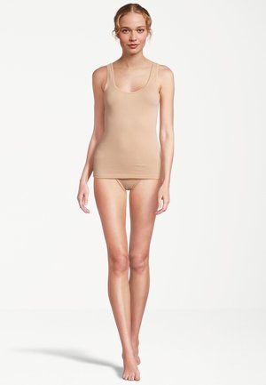 Canotta beige con spalline larghe e scollo rotondo, realizzata in tessuto liscio. Abbinata a biancheria intima senza cuciture coordinata.