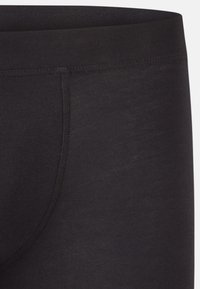 Musta stretchy kangasta leggingsit, joissa on sileä tekstuuri. Ominaisuuksiin kuuluu leveä joustava vyötärö ja istuva muoto. Yksityiskohtina on sivusauma.
