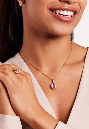 Gouden sieradenset met een ronde roze steen in een hangerketting en een bijpassende ring, beide met verfijnde ontwerpen en gladde oppervlakken.