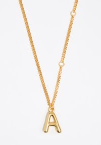 Collana in oro con un grande pendente lucido a forma di lettera "A". La catena è liscia con anelli uniformi, creando un aspetto contemporaneo.