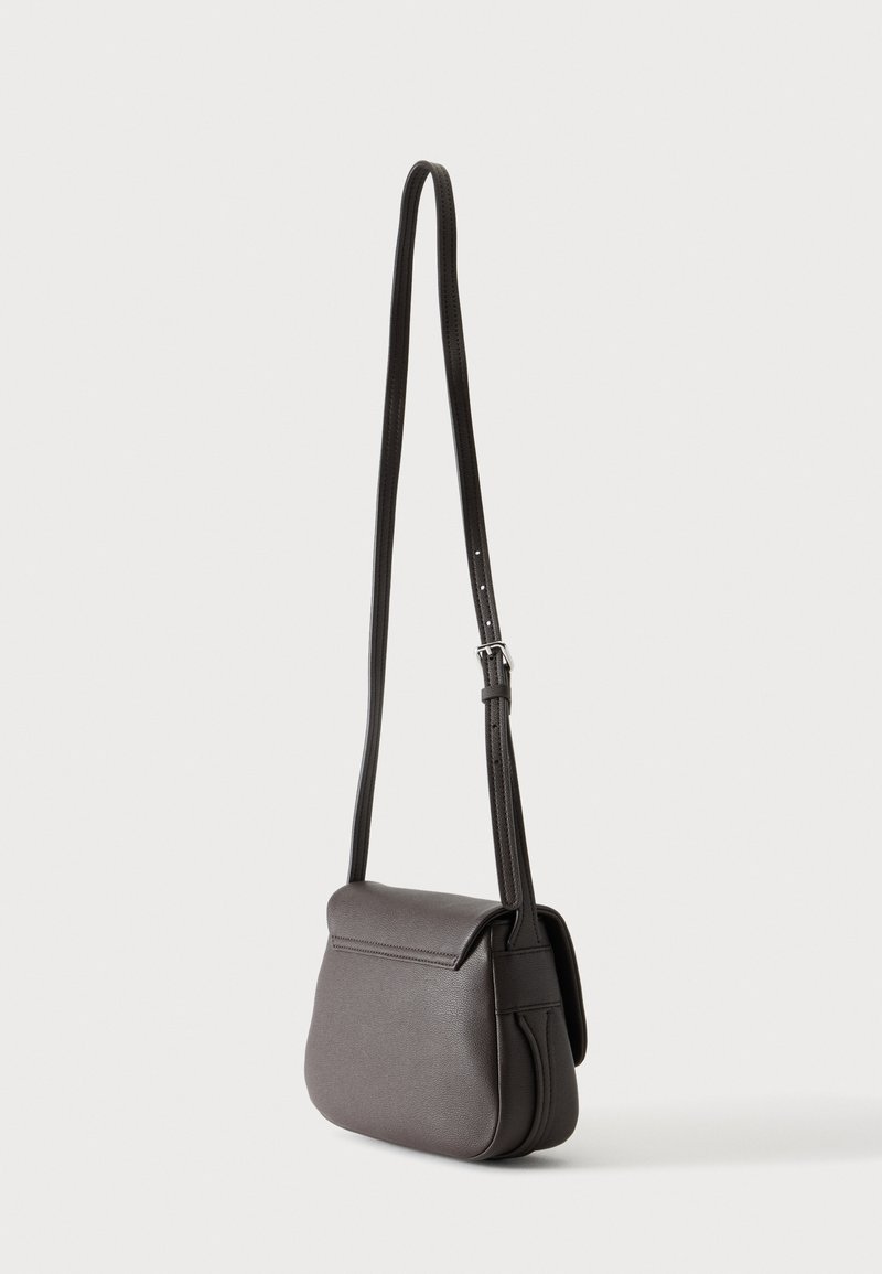 Piccola borsa a tracolla in pelle marrone scuro con una lunga tracolla regolabile e chiusura con patta, mostrata su uno sfondo semplice.
