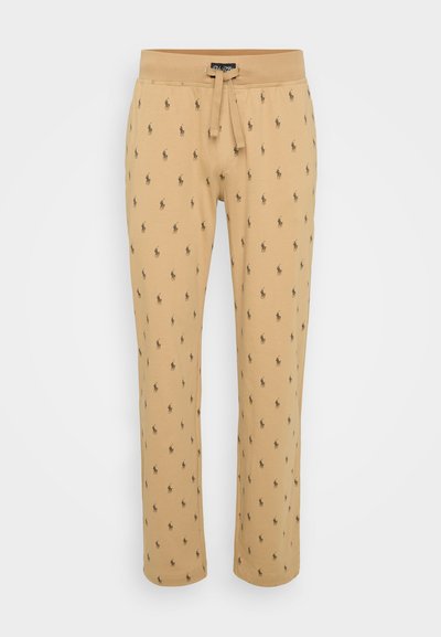 Gaišas smilškrāsas sporta bikses ar regulējamu jostasvietu, ar atkārtotu nelielu tumšu figūru rakstu, izgatavotas no mīksta, teksturēta materiāla.