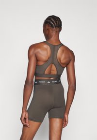 adidas Performance POWERREACT BIG LOGO GRAPHIC BRA - Lengvai krūtinę prilaikanti sportinė liemenėlė - shadow olive