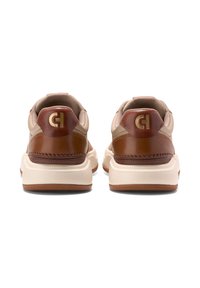 Skórzane, tanowe sneakersy z brązowymi akcentami i złotym logo na pięcie. Posiadają amortyzowaną podeszwę oraz teksturowane detale na cholewce.