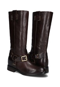 Bruine leren kniehoge laarzen met een gladde textuur, voorzien van een gespsluiting en decoratieve studs. Ontworpen met een lage hak en een ronde neus.