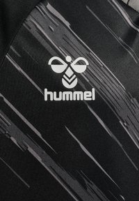 Schwarzes Sportshirt mit grauem abstraktem Muster. Enthält ein weißes "hummel"-Logo und einen strukturierten Stoffabschluss.