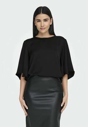 Zwart T-shirt met korte mouwen en een losse pasvorm, voorzien van een ronde halslijn, gecombineerd met een strakke zwarte leren rok, met een gladde textuur over het geheel.