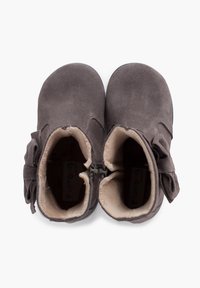 Bottines en suede marron avec une doublure intérieure douce, une fermeture éclair sur le côté et un nœud décoratif sur le côté extérieur.