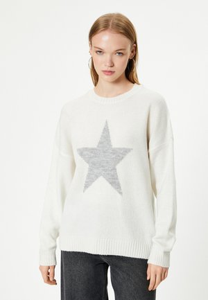 Witte gebreide trui met een grijs sterontwerp. Heeft een ronde halslijn, ribgebreide cuffs en zoom, en een oversized pasvorm met een zachte textuur.