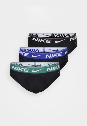 Trois paires de slips Nike en tissu noir avec des ceintures élastiques vertes, bleues et blanches, chacune marquée du logo Nike.