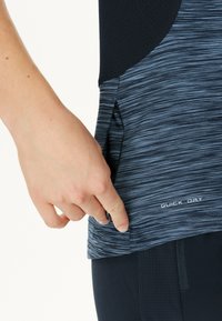 Kortärmad sporttop i en mörkblå och svart färgskala med ett melerat mönster. Har en snabbtorkande etikett nära fållen och sidoventil.