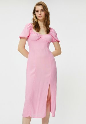 Pink midi kjole med puffærmer, tætsiddende overdel og sideslids. Glat stof med en gathered halsudskæring og en elegant silhuet.