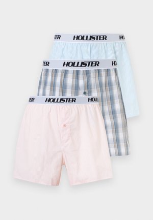 Kolm paari meeste puuvillaseid bokserid pastelse roosa triibulise, sinise ja beeži ruudulise ning helesinise triibulise mustriga, igaühel valge Hollisteri vöökohaga.