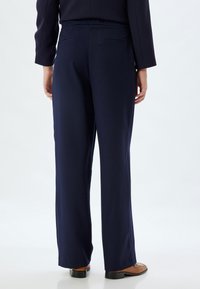 Marineblauwe broek met elastische taille en een rechte snit, voorzien van twee achterzakken en een soepele, lichte stof.