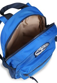 Zaino blu con un tessuto liscio e lucido, dotato di un compartimento principale con zip, una tasca laterale in rete e una patch con logo sul davanti.