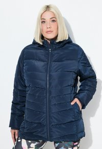 Chaqueta acolchada azul marino con cierre frontal, capucha y puños acanalados. Presenta costuras horizontales y bolsillos laterales para mayor funcionalidad.