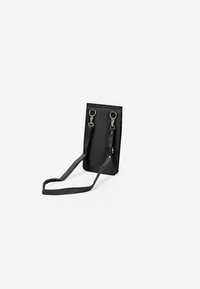 Bolso de hombro de cuero negro con forma rectangular, que cuenta con dos conectores en tono dorado y una correa delgada ajustable. Textura suave, diseño minimalista.