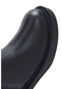 Calzature nere con tomaia in pelle liscia, design con punta arrotondata e suola in gomma spessa, con cuciture sottili lungo il lato.