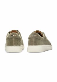 Green suede sneakers with white soles, rounded shape, and padded collar. Rear accents include three horizontal stripes in black and white.