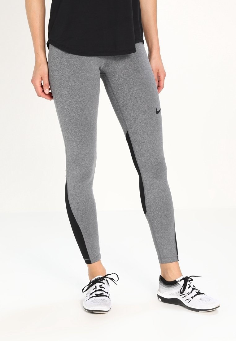 Leggings atletici grigi realizzati in un tessuto elasticizzato, con un pannello laterale nero, una texture liscia e un design aderente.