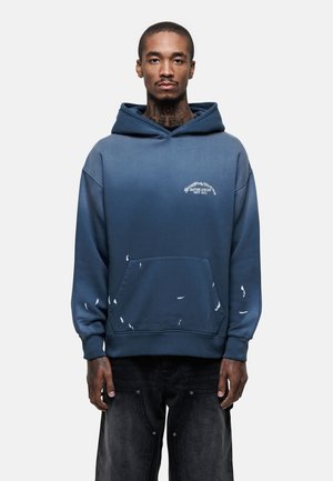 Blauer Ombre-Hoodie aus Baumwolle mit frontaler Tasche, Grafiklänge und abgenutzten Akzenten; verfügt über eine große Kapuze und gerippte Bündchen.