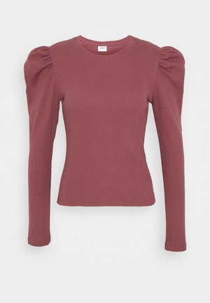 Mauve-värinen ribbineulottu pitkähiha, jossa liehuvat olkapäät ja pyöreä pääntie, istuva siluetti.