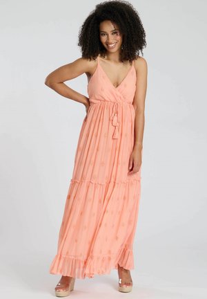 Perzik maxi-jurk met v-hals, verstelbare schouderbanden en gelaagde ruffles. Versierd met kleine gouden patronen door de stof heen.