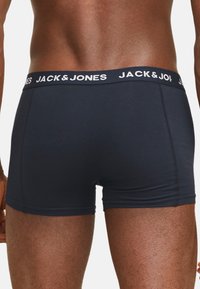 Marine boxers met een witte elastische tailleband waarop het logo "JACK & JONES" staat. De stof lijkt glad met een aansluitend ontwerp.