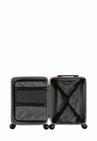 Hard-shell koffer in beige. Binnenkant met grijs stof, gaasvakjes en kruisstropen. Rol op vier zwarte wielen.