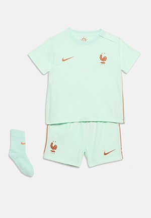 Kit da calcio verde chiaro per bambini con loghi Nike arancioni, stemma del gallo della Federazione Francese di Calcio su maglietta e pantaloncini, e un calzino abbinato.