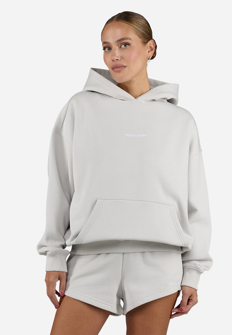 Helle graue, übergroße Kapuzenjacke aus weichem Stoff mit einer Taschen auf der Vorderseite. Sie verfügt über eine Kapuze mit Kordelzug und gerippte Bündchen. Dazu passende Shorts.