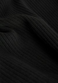 Črn rebrast material s nežno teksturo, ki ima ozke navpične črte po površini, kar ustvarja dinamičen vizualni učinek.