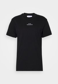 Czarna bawełniana koszulka z krótkim rękawem i okrągłym dekoltem. Na piersi znajduje się napis "PAS DE MORALISATEUR" w białym kolorze.