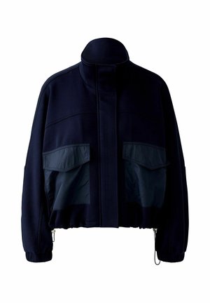 Veste marine avec un col montant, deux grandes poches avant à texture brillante, des poignets élastiques et un design légèrement court.