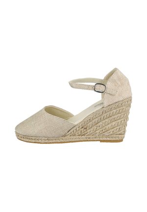 Sandalia con cuña beige con puntera cerrada, textura tejida, tira en el tobillo y detalles de cuerda trenzada en el tacón de plataforma.
