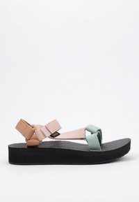 Sandalias planas con una suela texturizada negra. Cuentan con correas ajustables en rosa pálido y verde menta, hechas de material duradero para mayor comodidad.