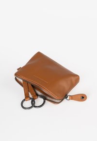 Brown leather wallet with a smooth texture, featuring a zip closure, two looped zipper pulls, and a compact rectangular shape.