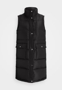 Svart pufferväst med hög krage, ärmlös design, knappstängning fram och två stora framfickor. Har kviltade paneler.