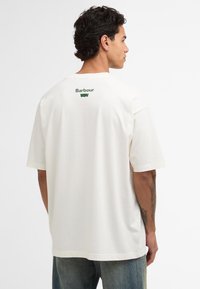Valge puuvillane t-särk, millel on mugav lõige, lühikesed varrukad ja roheline "Barbour" logo trükitud selja ülaossa. Klassikaline ümmargune kaelus.