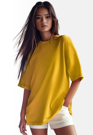 T-shirt oversize gialla in tessuto morbido, con maniche corte e orlo arrotondato, abbinata a pantaloni corti bianchi. Design semplice, senza fantasie.