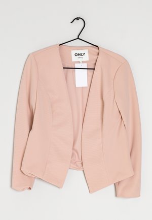 Helle rosa Blazer mit gerippter Textur, offenes Design und einem angehängten Etikett. Keine sichtbaren Knöpfe oder Verschlüsse. Hängt an einem schwarzen Haken.