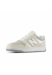 New Balance sneakers featuring a beige and white leather and suede upper, rounded toe, lace-up closure, and textured rubber sole.