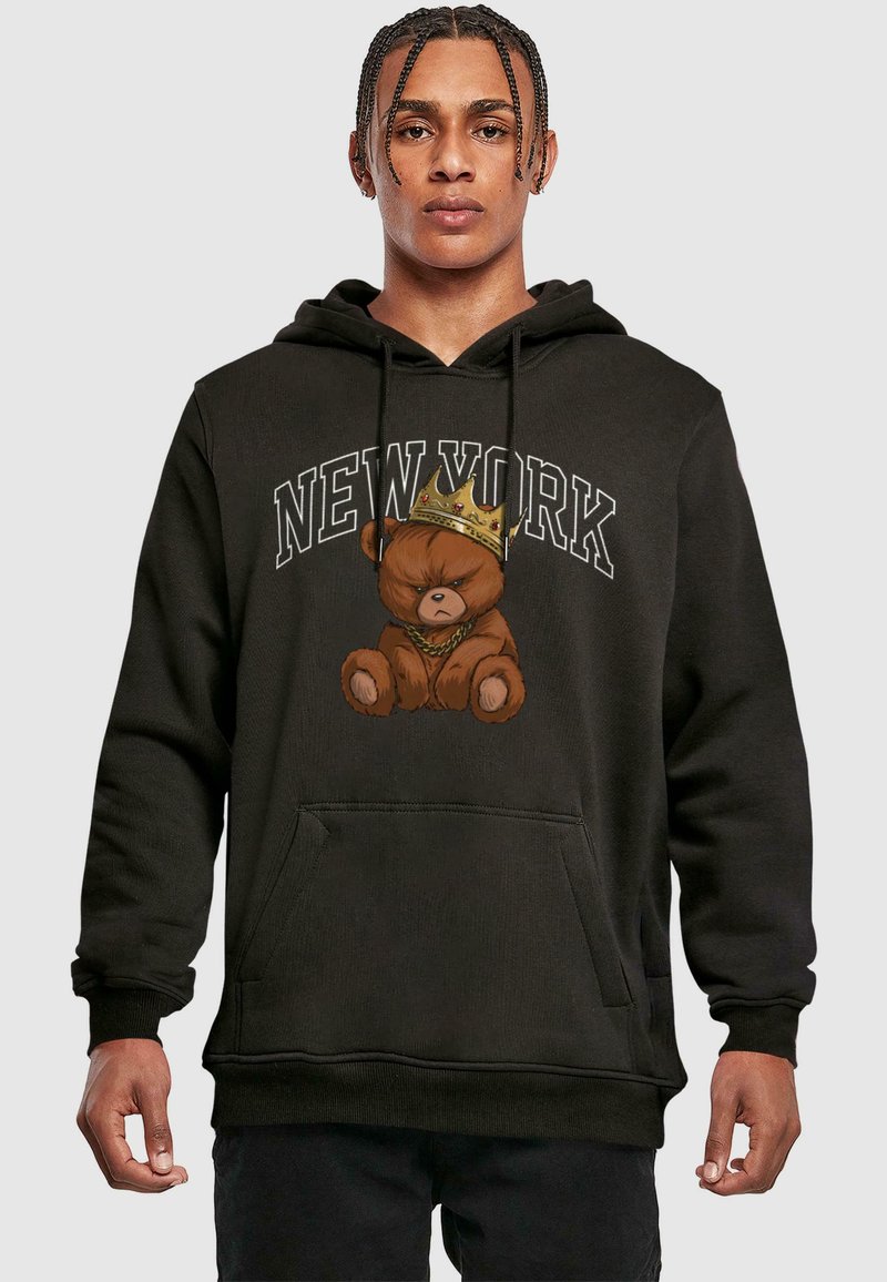 Sweat à capuche noir avec un ours en dessin animé portant une couronne, imprimé "NEW YORK" en blanc au-dessus. Il a une poche kangourou à l'avant et des poignets côtelés.