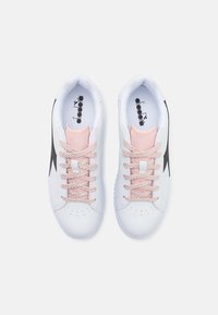 Scarpe da ginnastica bianche con accenti neri, con lacci e linguetta rosa. Materiale sintetico liscio e dettagli perforati.