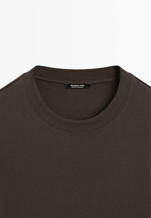 T-shirt a girocollo in cotone marrone con collo a coste. Presenta un'etichetta interna che indica "Massimo Dutti, Made in Portugal." Texture liscia.