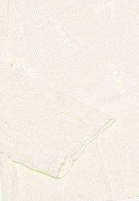 Crème-kleurige gebreide trui met een textuurpatroon, voorzien van lange mouwen en een geribbelde manchette. Zacht, lichtgewicht stof met subtiele details.