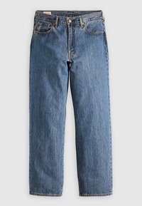 Blå denim raklöss jeans med fem fickor, metallknappsstängning och orange sömnad på vit bakgrund.