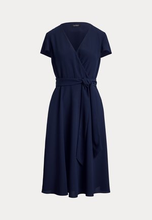 Κομψό φόρεμα navy μπλε μέχρι το γόνατο με κοντά μανίκια και ζώνη στη μέση, κατασκευασμένο από ελαφρύ ύφασμα.