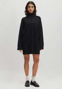 Schwarzes,oversized Rollkragenkleid aus weichem Material, mit langen Ärmeln und einem lockeren Schnitt, geradem Saum und gerippten Bündchen.